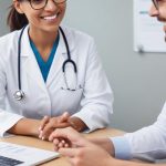 Smiling doctors discussing patient records at a desk