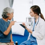 Caucasian doctor smiling take care of a young patient in hospital. Friendly nurse or therapeutic
