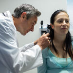 Caucasian male doctor examining a Caucasian pregnant woman