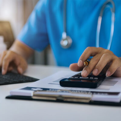 Doctor with calculate medical fee costs and revenue.