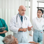 professional doctor standing by explain the treatment information via male elderly patient