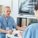 Mature Doctor Talking to Colleague in Clinic