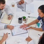 Above discussion of medical teamwork, meeting or paperwork report of test results at table.