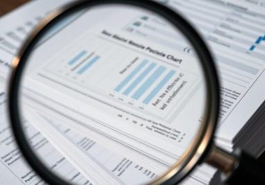 Magnifying glass over ENT billing performance charts.